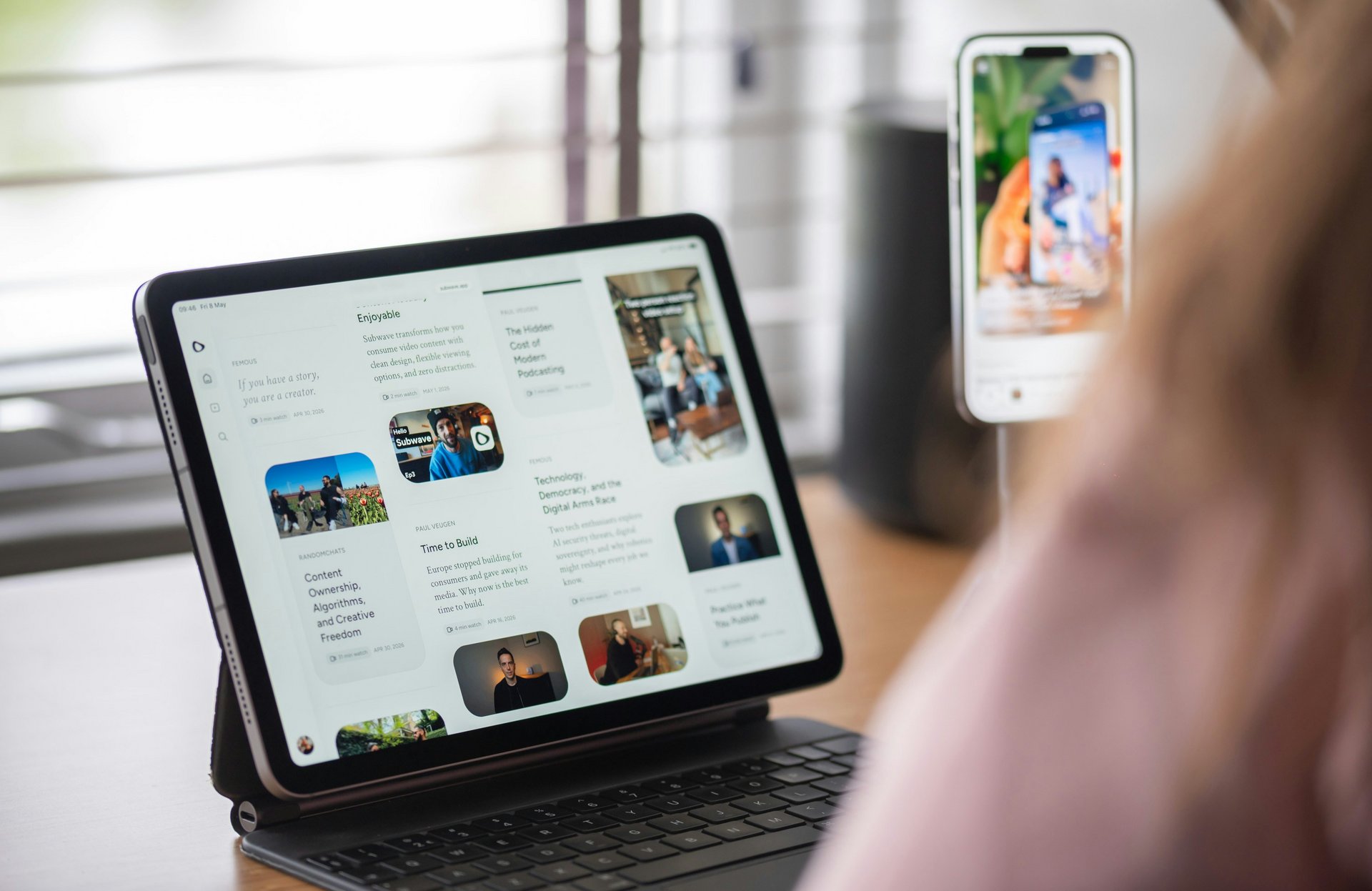 Blick über die Schulter einer Frau, sie schaut sich auf einem iPad eine Blogübersicht an.